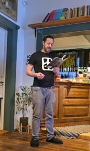 Kirjanik, luuletaja, tõlk Adam Cullen esitamas oma kohvikus-raamatupoes Pagu Haapsalus oma luuletust "Vihm" / "Rain"